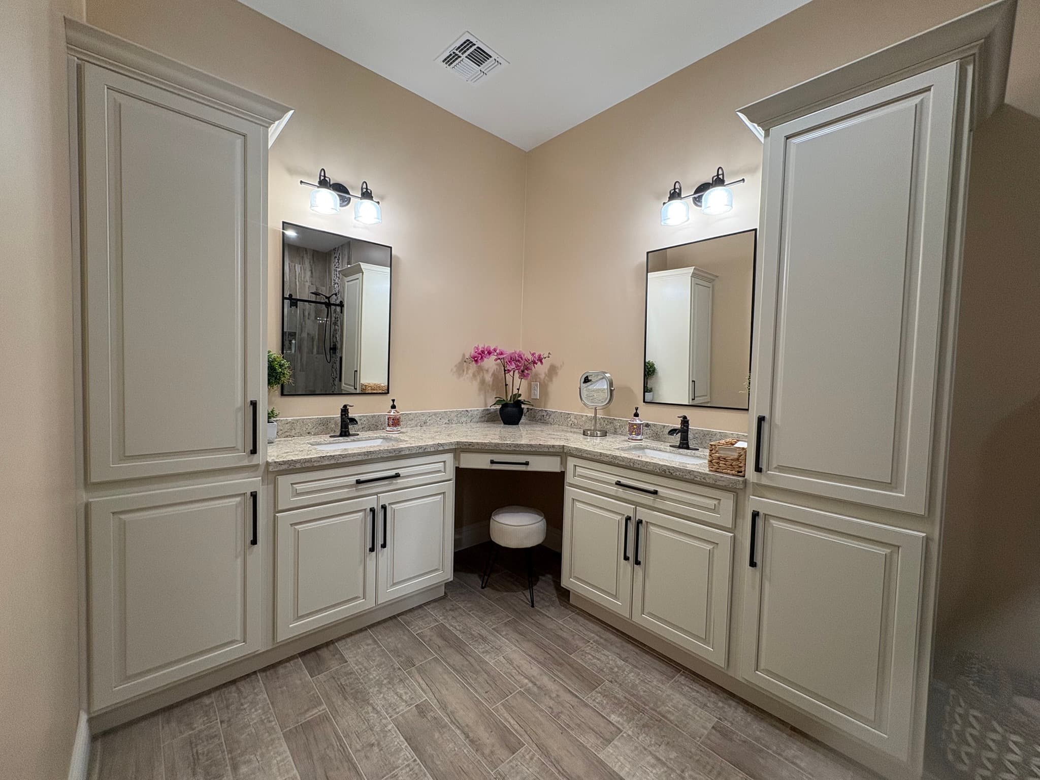 Completed bathroom vanity with sink, mirror, lighting, and cabinet storage